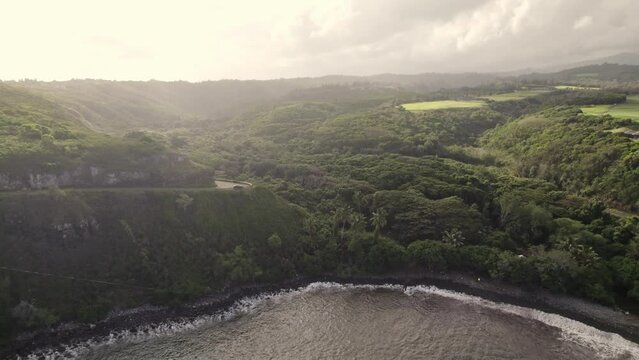 A backward drifting aerial provides a view of Honokohau Bay and the splendor of the islands. Tropical rain and mist fill the distance as one would expect in this chain of mountainous microclimates