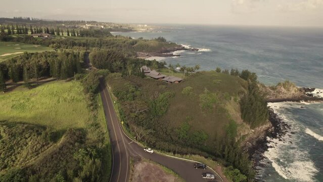 Aerial showing the beautiful coastline of Maui, Hawaii during a warm sunset.  Honoapilani Highway winds around the coast revealing the amazing geology and rugged coastline