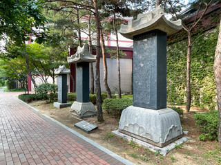 A walking path with a stone monument in the garden behind the Seoul Museum of History