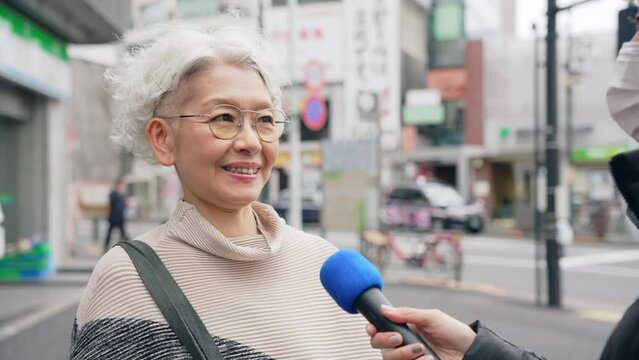 街頭インタビューを受けるシニア女性