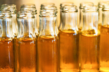 Close up small bottle glass of fresh Chrysanthemum tea, group of cold Chrysanthemum tea in cleared bottles, water drops on bottles, warm light.