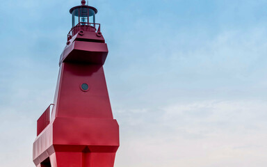 Closeup of red lighthouse built in shape of horse on concrete pier.