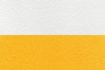 Texture of craft white and bright yellow paper background, half two colors, macro. Vintage dense orange cardboard.