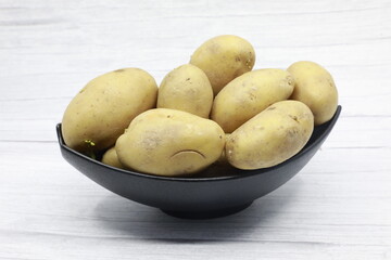 Young potato isolated on wooden background