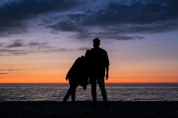 company of people on the beach at sunset.Silhouettes of people at sunset.Beach,sea,relax,evening