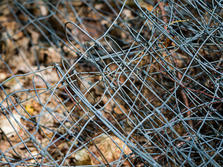 a broken fence and wire around a tree in the forest