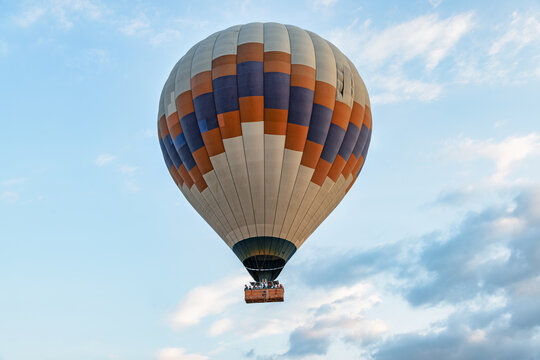 Closeup view of flying colorful hot air balloon at sunrise