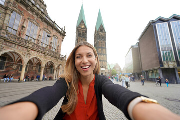 Tourism in Germany. Beautiful woman takes self portrait in Bremen Market Square with Cathedral and City Hall, Bremen, Germany. - obrazy, fototapety, plakaty