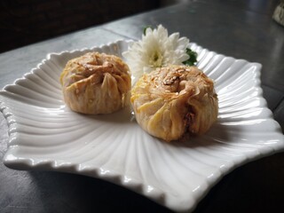 Spring Rolls with Round Red Bean Paste Placed in a white plate.