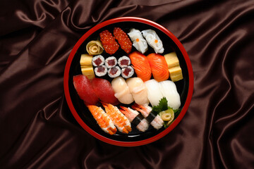 Sushi Set sashimi and sushi rolls served in traditional Japan round plate - Top view