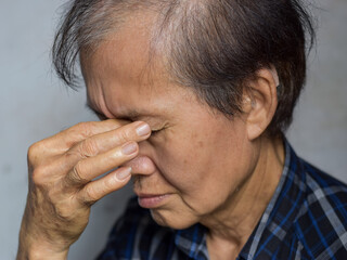 Asian man massaging his eye. Concept of eye pain, strain or itchy eyelid.