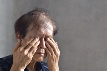 Asian man rubbing his eye. Concept of eye pain, strain or itchy eyelid.