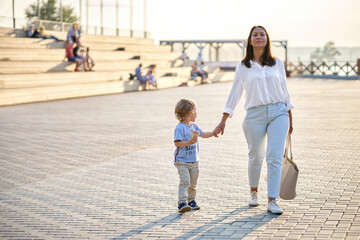 Mother and son enjoy sunset views at public urban park