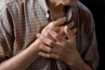 Asian man suffering from central chest pain. Chest pain can be caused by heart attack, myocardial...