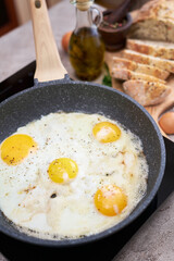 Fried Egg in cast iron frying pan on black induction hob