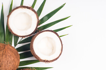 Ripe half cut coconut with green leaves on a white background. Isolated concept.