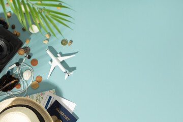 Miniature toy airplane, travel accessories and paper clouds on blue background. Flat lay design of...