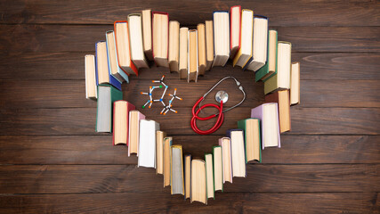 Medical degree education concept - books in heart shape, molecule model and stethoscope on the...