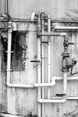 Old pipes and valves against white wall