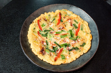 Korean Haemul Pajeon, Korean seafood green onion scallion pancake on black table background
