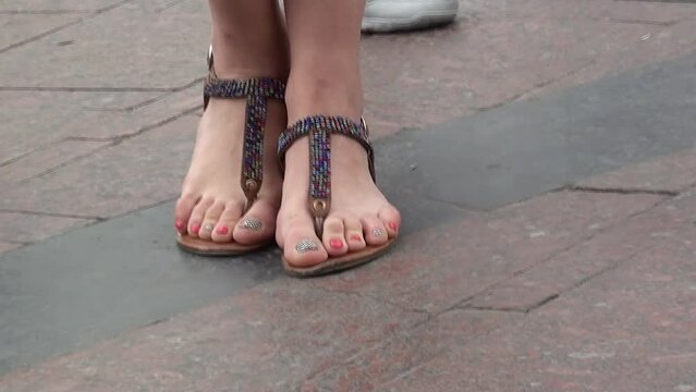 The girl poses for a photo session. Feet in nice fashionable sandals