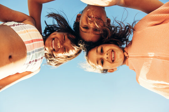 Low angle view of kids smiling happily at the beach