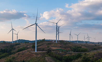 Wind turbine field with blue sky background at sunset. renewable energy