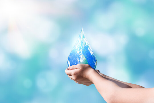 Hands holding global in drop shape on blurred nature background. World day for water and sustain for earth concept. Elements of this image furnished by NASA