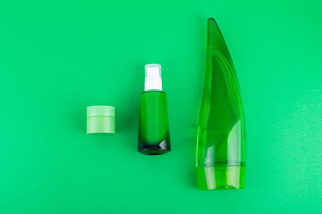 moisturizes serum, jar of cream on green background. Moisturizing beauty product with organic. Body care lotion. Simple empty packaging beauty cosmetics. Mock up, copy space