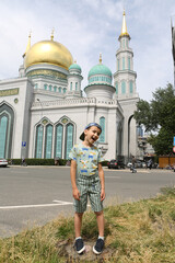 Obraz premium Tourist boy, cute child, fashion kid and Moscow Cathedral Mosque in Moscow city, Russia. Child and Moscow landmark, monument, sight, view. Islamic, muslim architecture