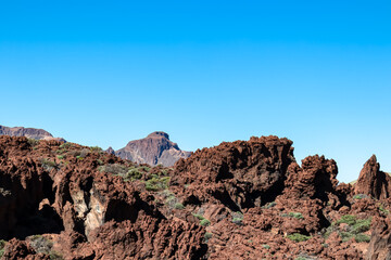 Panoramic view on mount El Sombrero in volcano Mount Teide National Park, Tenerife, Canary Islands, Spain, Europe. Volcanic barren desert landscape. Hiking trail on sunny day. Marsian rock formation