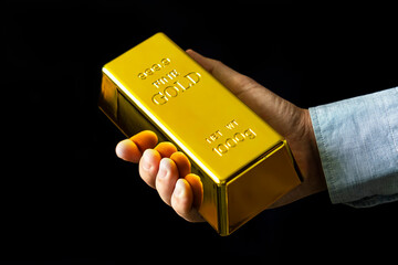 Present 1000 g of fine gold bars. a man holds gold on a black background.
