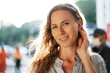 Portrait of a charming young woman posing for camera in the city