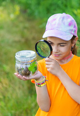 The child looks at the snail. Selective focus.
