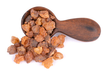 Myrrh resin in wooden spoon, isolated on white background. Pile of natural Commiphora myrrha. Sweet...