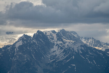 Naklejka premium Beautiful snow covered mountains with in the fog and dramatic clouds.