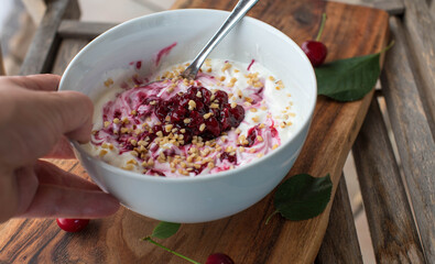Low carb breakfast bowl with quark, warm cherry compote and roasted nuts