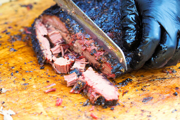 Cutting the finished brisket with a knife. Brisket bbq smoked beef sincled in foil - 518059714