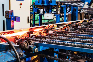 Machine for induction heating of metal. A metal rod heated in an induction furnace. Hot metal processing. Metalworking in the industrial workshop at the factory.