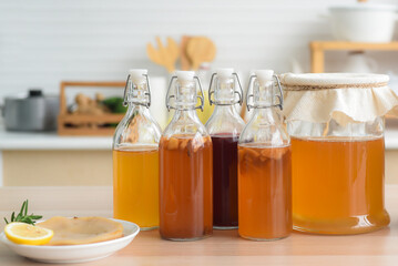 Homemade fermented raw kombucha tea, variety of flavors in bottles and glass jars mix with a fruit...