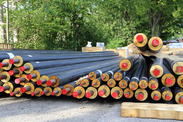 Different dimensions of heating pipes laying near a construction site. Sustainable energy concept.