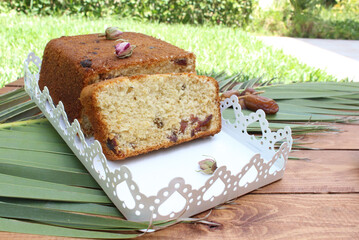 Gluten-free cake recipe with date fruit on palm and rustic wooden background