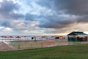 Fototapeta premium Sea deserted beach after heavy rain, storm clouds over the sea. Bad weather at the resort