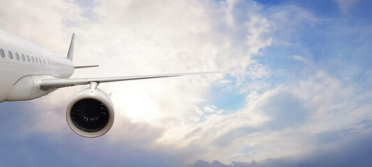 White commercial passenger airplane on sky clouds background. Travel by plane, transportation concept