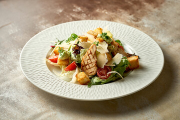 Caesar salad with grilled chicken in a plate. A selective trick. Close-up. Noise in post-production