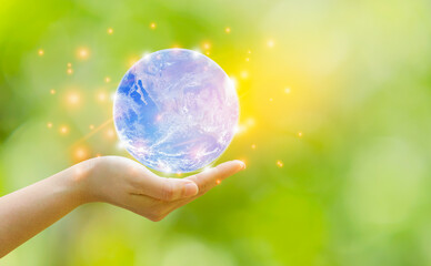 Woman hand holding earth  on natural blur backgroun.