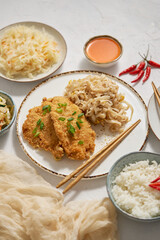 Thai style fried crispy chicken breast in breadcrumbs served with rice noodles