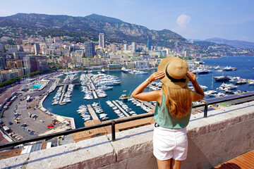 Aerial view of beautiful girl in Monte-Carlo looking cityscape with skyscrapers and harbor in Monaco City-State - obrazy, fototapety, plakaty