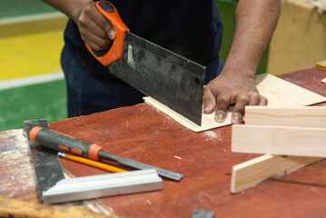 Hands of a carpenter man cutting wood