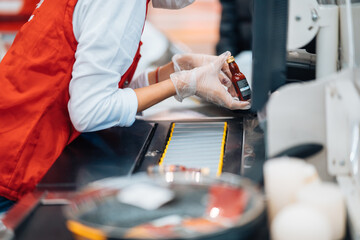 A woman reads the barcode at checkout machine in supermarket